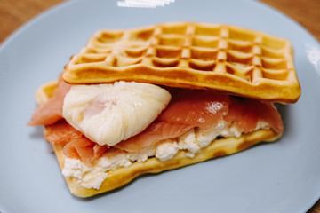 tasty Belgium waffle with lettuce, meat, egg and vegetables served of pretty blue plate