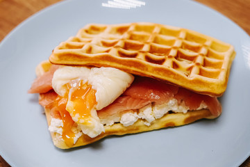 tasty Belgium waffle with lettuce, meat, egg and vegetables served of pretty blue plate