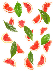 Slices of juicy grapefruit and leaves on white background