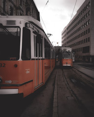 Orange Trains in caught in action in city streets of Budapest Hungary