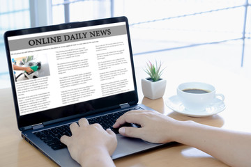 Businessman reading news on laptop at office desk