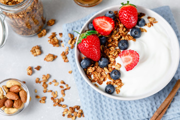 Homemade oatmeal granola bowl with greek yogurt, berries, honey and nut