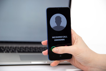 Woman holding phone with incoming unknown call isolated