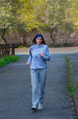 A girl in a tracksuit runs. Red-haired athlete.
