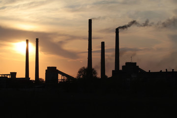 Fototapeta na wymiar .Smoking chimneys of a plant against the setting sun