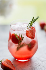 Cold drink with strawberry, rosemary and ice