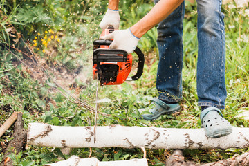 A man works on creating a house, sawing wood, building, saw, power saw, chisel, nails, screws