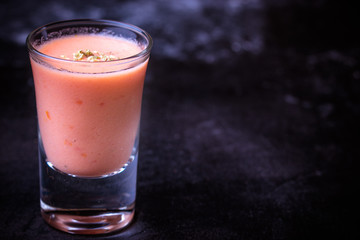 Andalusian gazpacho in shot glass with black background
