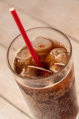 Cold soda drink in a glass with straw