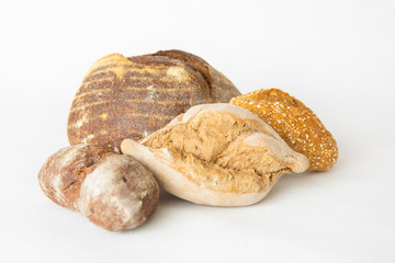 Tasty crispy wheat and rye loafs. Batch of different bread and buns isolated on white background. Studio shot. Front view. Homemade food and nutrition concept