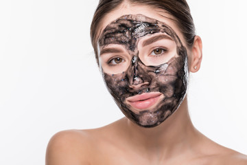 Young woman with purifying black mask on her face isolated on white background