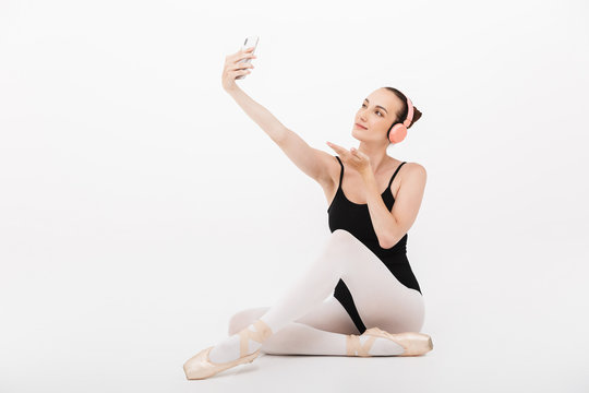 Image of woman ballerina in headphones taking selfie photo on cellphone