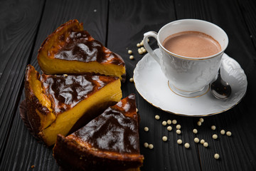 Hot chocolate in a white dish with cakes on a dark background 