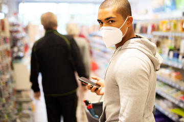 Ein Mann mit Atemmaske wartet im Supermarkt in der Schlange