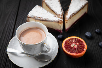 Hot chocolate in a white dish with cakes on a dark background 