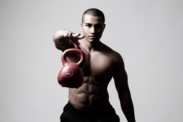 Junger muskulöser Mann trainiert mit einer Kugelhantel, Training mit einer Kettlebell 