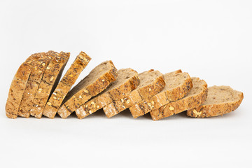 Homemade loaf with poppyseeds and cereals cutting on slices. Sliced bread made of rye flour isolated on white background. Studio shot. Side view. Home culinary and baking concept