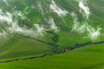 Fototapeta premium Pieces of fog on the green mountains