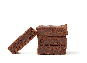 stack of square baked pieces of brownie chocolate cake isolated on a white background, delicious dessert