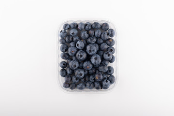 blueberry in plastic container box, isolated over a white background