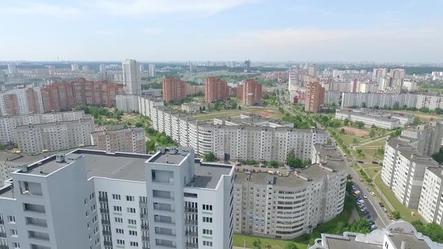 a flight in the city in front of a multi-storey building, long houses of gray and red color, a residential area,