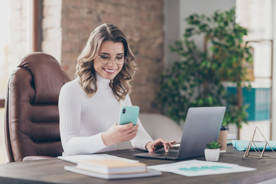 Portrait of her she nice attractive cheerful focused wavy-haired girl marketing director using digital device sending sms in modern loft brick industrial interior style workplace workstation