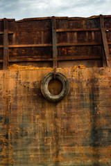 Old car tire on rusty ship