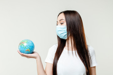 woman looking at planet earth globe wearing mask isolated on white background