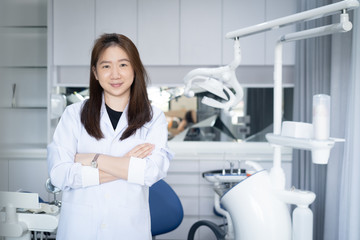 Portrait of female dentist .She standing in her dentist office.