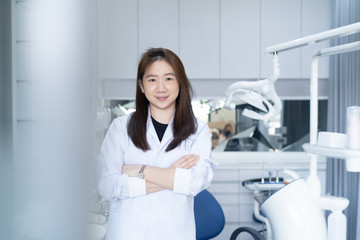 Fototapeta premium Portrait of female dentist .She standing in her dentist office.