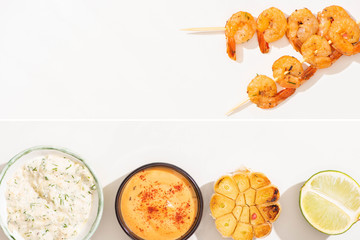 collage of delicious fried prawns on skewers with garlic, lime and sauces on white background