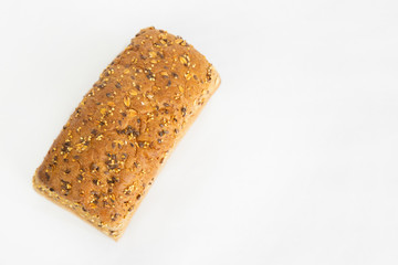 Tasty brick form bread baked at home. Soft whole loaf with cereals, oats, seeds isolated on white background. Studio shot. Top view. Homemade bakery and cooking at home concept