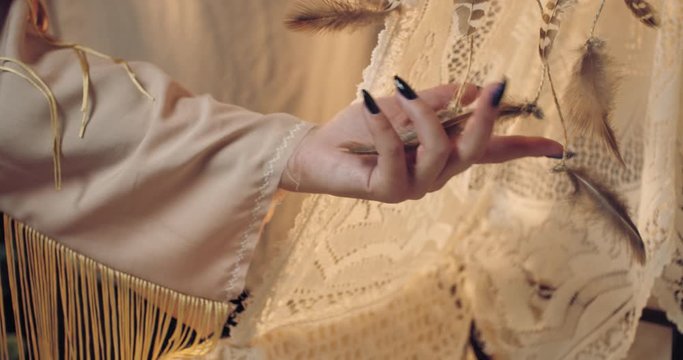 Close up of a mother touching the feathers in the cradle, native american, 4k