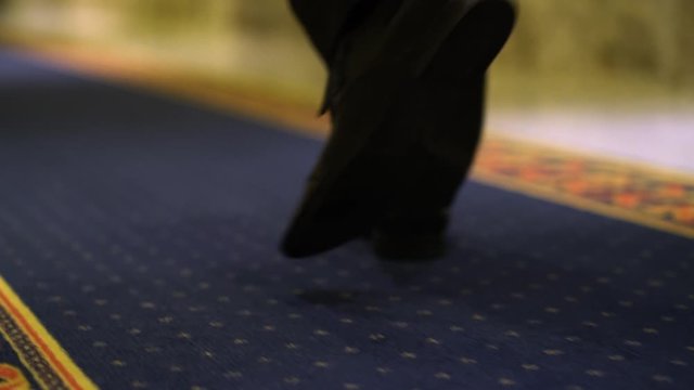 Businessman walking on carpet in hotels. Close-up.