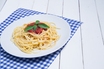 Spaghetti pasta with and tomato sauce on wood background