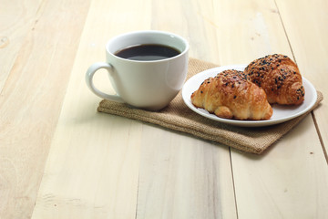 Croissant and coffee  isolated on wood table