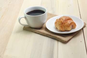 Croissant and coffee  isolated on wood table