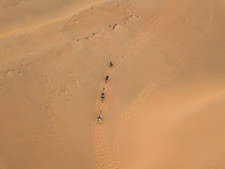 lompoul desert yellow sand photographed from the air in Africa camels and drivers go by caravan in...