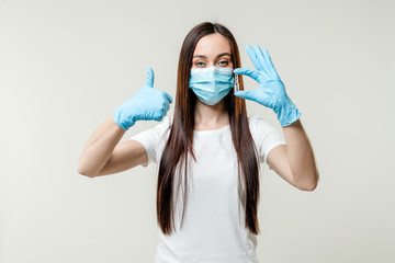 woman holding vaccine drug in ampoule wearing mask and gloves  isolated on white background