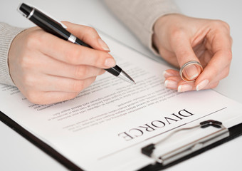 Woman signing divorce settlement agreement