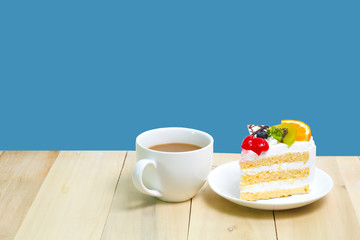Slice cake with coffee cup on wood ,  blue background