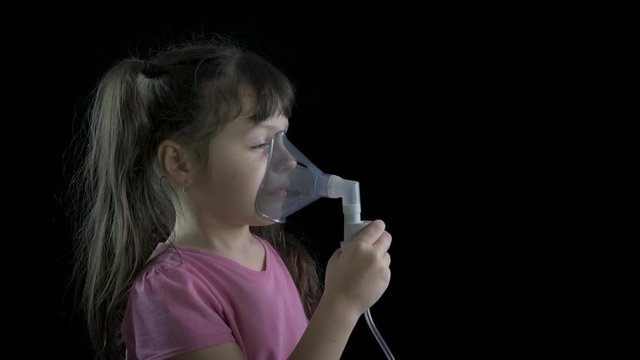 Inhaling medication. Cute little girl breathes steam from a nebulizer.