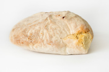 Crusty wheat bread baked at home. Fresh white loaf isolated on white background. Studio shot. Side view. Homemade food and baking at home concept