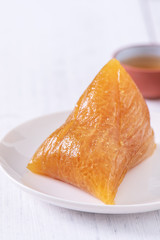 Zongzi - alkaline Chinese rice dumpling crystal food on a plate to eat for traditional Dragon Boat Duanwu Festival concept, close up.