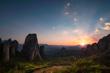 the rocksof Meteora standing in the last light of the day