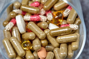 medicine pills and capsules on grey surface