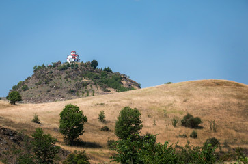 an orthodox church is standing up the hill in a greek landscape