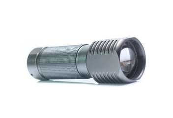 Metal flashlight over white background