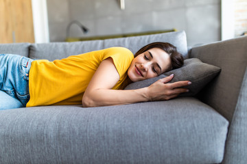 Fototapeta premium Young sleeping woman is lying on a pillow on a couch