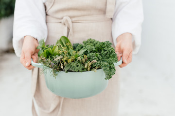 Close up of a teal pot filled garden green vegetables and herbs